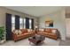 Bright living room features matching leather sofas, plush rug, and large windows at 2513 Elkcam Blvd, Port Charlotte, FL 33952