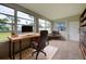 Home office features a large wooden desk, comfortable chair, and ample natural light at 2513 Elkcam Blvd, Port Charlotte, FL 33952