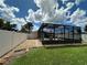 Large backyard featuring a screened pool and lush lawn at 829 Pineland Ave, Venice, FL 34285