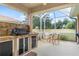 Outdoor kitchen with built-in grill, sink, and cabinets at 6709 Grand Cypress Blvd, North Port, FL 34287