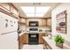 Bright kitchen featuring wood cabinets, granite countertops, and a microwave at 1515 Forrest Nelson Blvd # H108, Port Charlotte, FL 33952