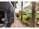 Private walkway leads to a screened patio with seating area and lush landscaping at 1515 Forrest Nelson Blvd # H108, Port Charlotte, FL 33952