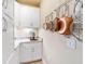 Charming galley style kitchen with white cabinets, copper sink, and pot rack at 15378 Taurus Cir, Port Charlotte, FL 33981