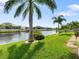 Landscaped backyard with canal view and palm trees at 15378 Taurus Cir, Port Charlotte, FL 33981