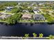 Aerial view of waterfront home with pool and lush landscaping at 15378 Taurus Cir, Port Charlotte, FL 33981