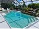 Inviting, refreshing pool area with a waterfall feature and screened enclosure at 181 N Waterway Nw Dr, Port Charlotte, FL 33952