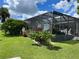 Spacious backyard with screened patio and lush landscaping at 181 N Waterway Nw Dr, Port Charlotte, FL 33952