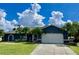 Single-story home with blue exterior, white garage door, and landscaping at 181 N Waterway Nw Dr, Port Charlotte, FL 33952