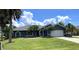 Single story home with blue exterior, white garage door, and palm trees at 181 N Waterway Nw Dr, Port Charlotte, FL 33952