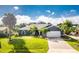 Single-story home with a gray exterior, lush landscaping, and a two-car garage at 181 N Waterway Nw Dr, Port Charlotte, FL 33952