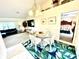 Charming dining room with glass-top table and chairs, offering views into the living and kitchen at 181 N Waterway Nw Dr, Port Charlotte, FL 33952