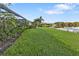 Spacious backyard with pond view and screened patio at 3589 Pennyroyal Rd, Port Charlotte, FL 33953