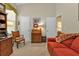 Bright office space with a sofa, wooden desk, and built-in shelving at 3589 Pennyroyal Rd, Port Charlotte, FL 33953