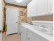 Bright laundry room with washer, dryer, and cabinets at 3589 Pennyroyal Rd, Port Charlotte, FL 33953