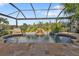 Inviting kidney-shaped pool with a waterfall feature and a screened enclosure at 3589 Pennyroyal Rd, Port Charlotte, FL 33953