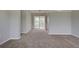 Spacious living room with neutral carpeting and access to a sunroom at 2513 Elkcam Blvd, Port Charlotte, FL 33952