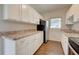 Modern kitchen with white cabinets, granite countertops, and stainless steel appliances at 2513 Elkcam Blvd, Port Charlotte, FL 33952