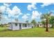 Landscaped backyard with single-story home and palm tree at 2513 Elkcam Blvd, Port Charlotte, FL 33952