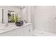 Bright bathroom featuring dual sinks, white cabinetry, a large mirror, and a tiled walk-in shower at 16390 Bridle Ridge St, Port Charlotte, FL 33953