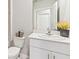 Well-lit bathroom with white cabinets, a modern faucet, decorative plants, and a convenient toilet at 16390 Bridle Ridge St, Port Charlotte, FL 33953