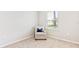 Cozy bedroom corner with a comfortable chair and natural light from the window, neutral paint at 16390 Bridle Ridge St, Port Charlotte, FL 33953