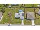 Aerial view of a single Gathering home with solar panels, fenced in yard, and a screened-in pool at 17341 Sabrina Cir, Port Charlotte, FL 33948