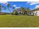 Palm trees and lush foliage surround the screened-in pool, providing a backyard oasis at 17341 Sabrina Cir, Port Charlotte, FL 33948