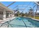 The pool area is enclosed with a screen and includes a handrail for easy access at 17341 Sabrina Cir, Port Charlotte, FL 33948