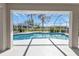 The screened-in pool is viewed from the covered patio and is ready for backyard enjoyment at 17341 Sabrina Cir, Port Charlotte, FL 33948