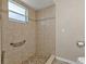 Tiled shower with a grab bar, neutral walls and a window at 17341 Sabrina Cir, Port Charlotte, FL 33948