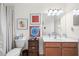 Charming bathroom with wooden vanity, decorative artwork, and a shower with curtain at 5241 Grand Palmetto Way, North Port, FL 34291