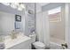 Bright bathroom features a shower-tub combo, decorative artwork, and a white vanity at 5241 Grand Palmetto Way, North Port, FL 34291