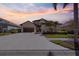 Beautiful two-story stucco home with tile roof, lush landscaping, two-car garage, and spacious driveway at sunset at 5241 Grand Palmetto Way, North Port, FL 34291