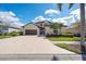 Charming two-story stucco home with tile roof, lush landscaping, and spacious driveway leading to the attached two-car garage at 5241 Grand Palmetto Way, North Port, FL 34291