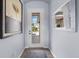Clean and modern foyer with neutral walls and a view of the front yard through the glass-paned front door at 5241 Grand Palmetto Way, North Port, FL 34291