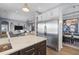Open kitchen features stainless steel appliances, an island with sink, and a view into the living and dining areas at 5241 Grand Palmetto Way, North Port, FL 34291