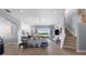 Bright and open living room with hardwood floors, staircase, fan, and large windows overlooking the backyard at 5241 Grand Palmetto Way, North Port, FL 34291