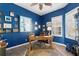 Well-lit office with blue walls, neutral floors, natural light, and a large wooden desk at 5241 Grand Palmetto Way, North Port, FL 34291