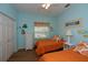 Bedroom with two twin beds, orange bedding, and light blue walls at 1274 White Oak Trl, Port Charlotte, FL 33948