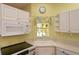 Kitchen corner sink and appliances with white cabinets at 1274 White Oak Trl, Port Charlotte, FL 33948