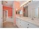 Bathroom with double vanity, coral walls and a garden tub at 1274 White Oak Trl, Port Charlotte, FL 33948