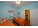 Bedroom with two twin beds, orange bedding, and light blue walls at 1274 White Oak Trl, Port Charlotte, FL 33948