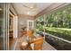 Relaxing screened porch with wicker dining set and view to backyard at 1274 White Oak Trl, Port Charlotte, FL 33948