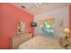 Bedroom with coral walls, wicker dresser, and floral bedding at 1274 White Oak Trl, Port Charlotte, FL 33948