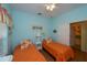 Bedroom with two twin beds, orange bedding, and light blue walls at 1274 White Oak Trl, Port Charlotte, FL 33948