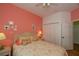 Primary bedroom with coral walls, wicker furniture and double closet at 1274 White Oak Trl, Port Charlotte, FL 33948