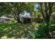 Home with a spacious backyard, lush landscaping, and large shade trees at 1274 White Oak Trl, Port Charlotte, FL 33948