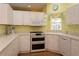 Kitchen features white cabinets, double oven, and corner sink at 1274 White Oak Trl, Port Charlotte, FL 33948