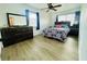 Bright bedroom with a queen bed and dresser, featuring wood-look flooring at 14300 Worthwhile Rd, Port Charlotte, FL 33953