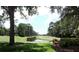 Serene golf course view with trees, water feature, and lush greens at 13139 Preserve Ct, Port Charlotte, FL 33953